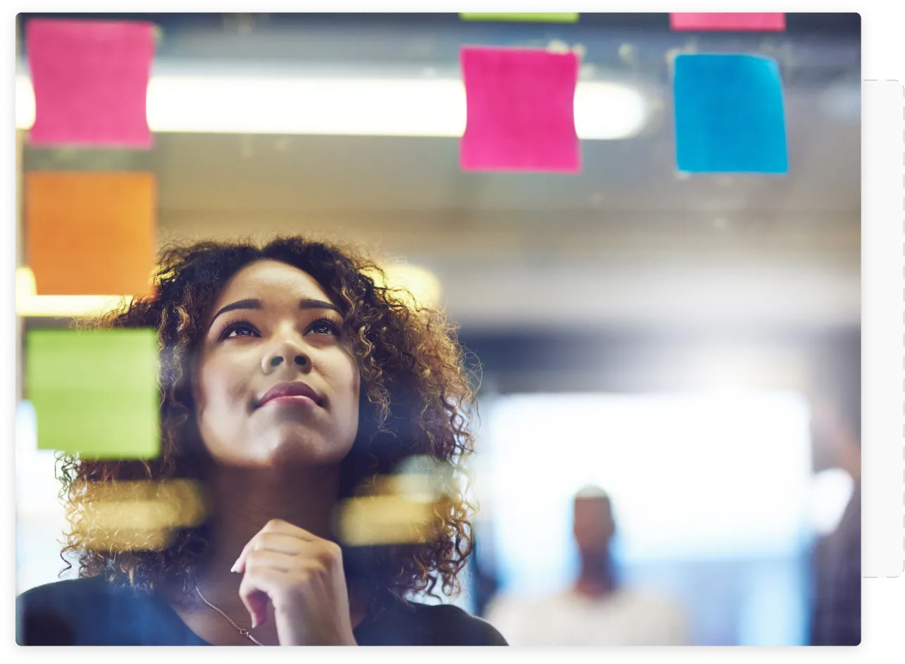 A woman throw a glass board looking at post-its